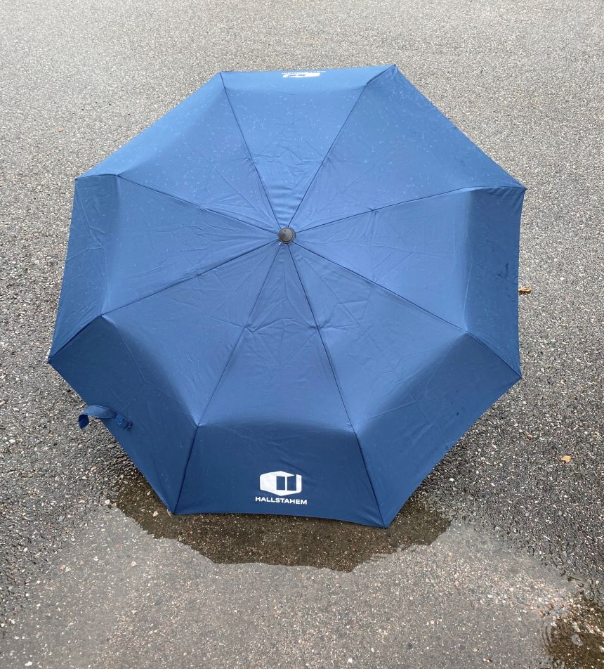 Paraply som ligger på asfalten