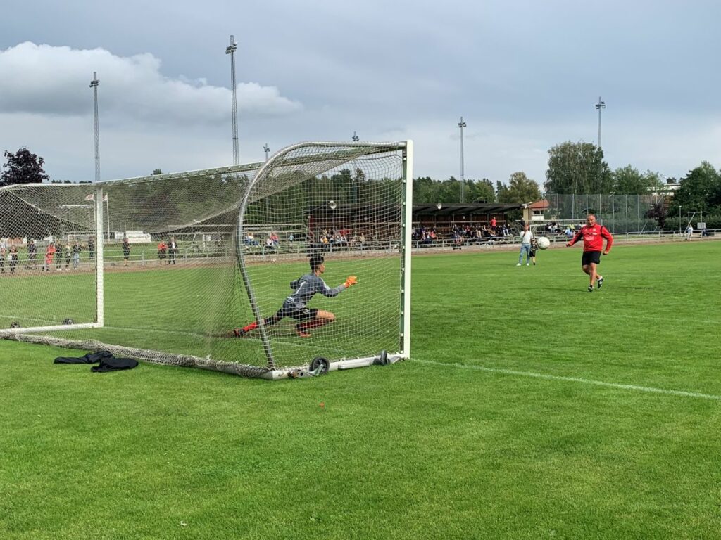 Fotbollsmålvakt står i mål och får en straff sparkad på sig