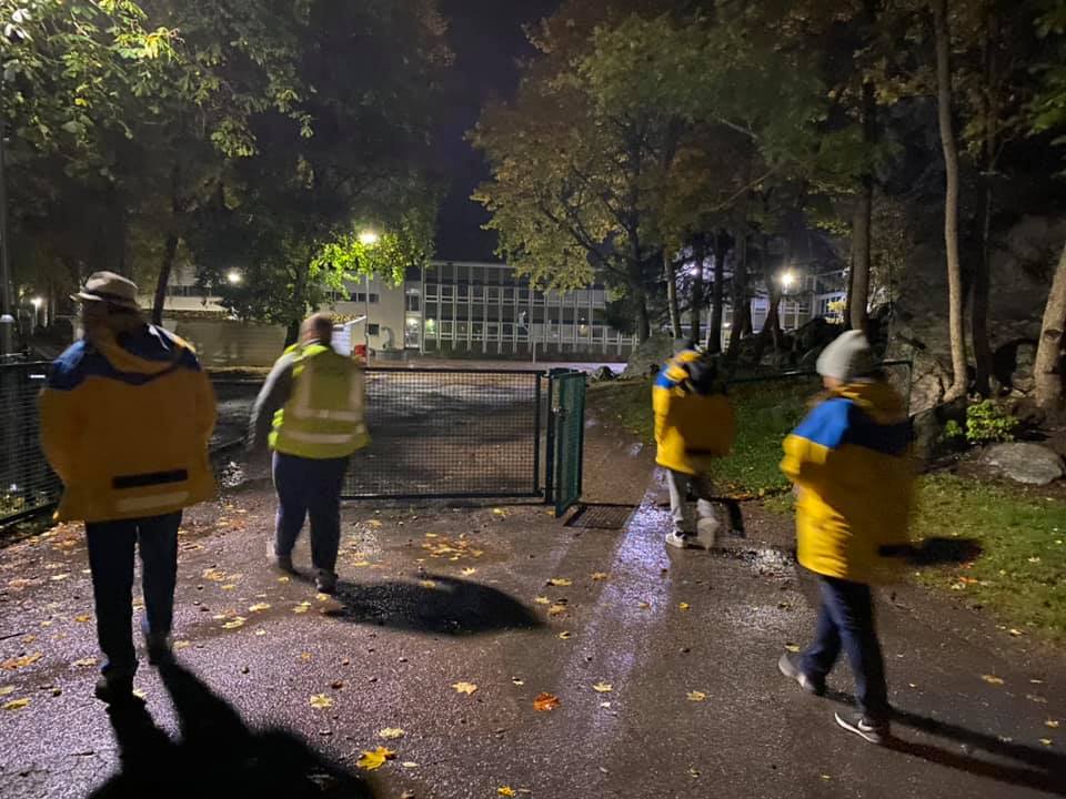 Flera vuxna personer vandrar i mörkret