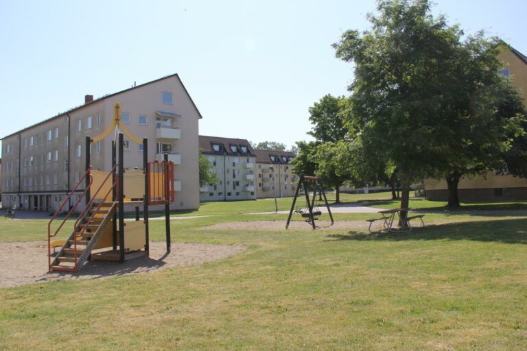 Lekpark med stor grönyta och flera lägenhetshus runtom