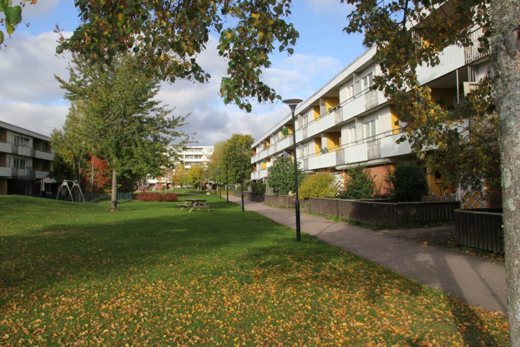 Stor innehård med gräsmatta mellan lägenhetshusen