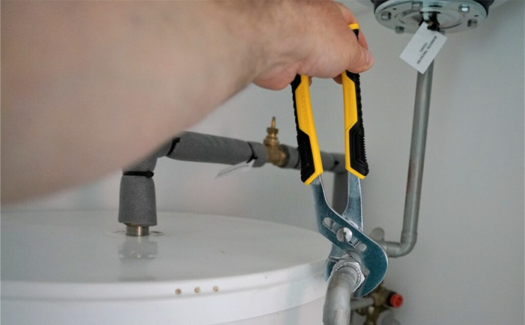 Person skruvar på ett vattenrör