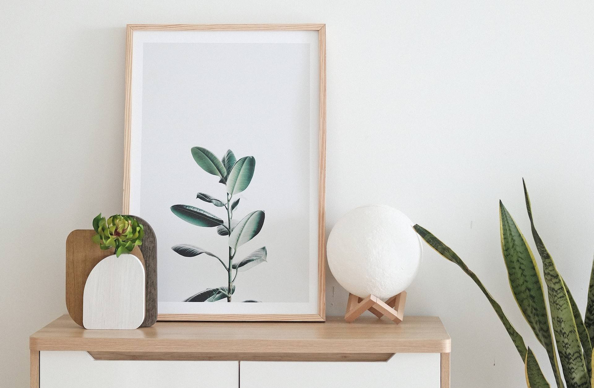 Vit vägg med en träfärgad byrå framför