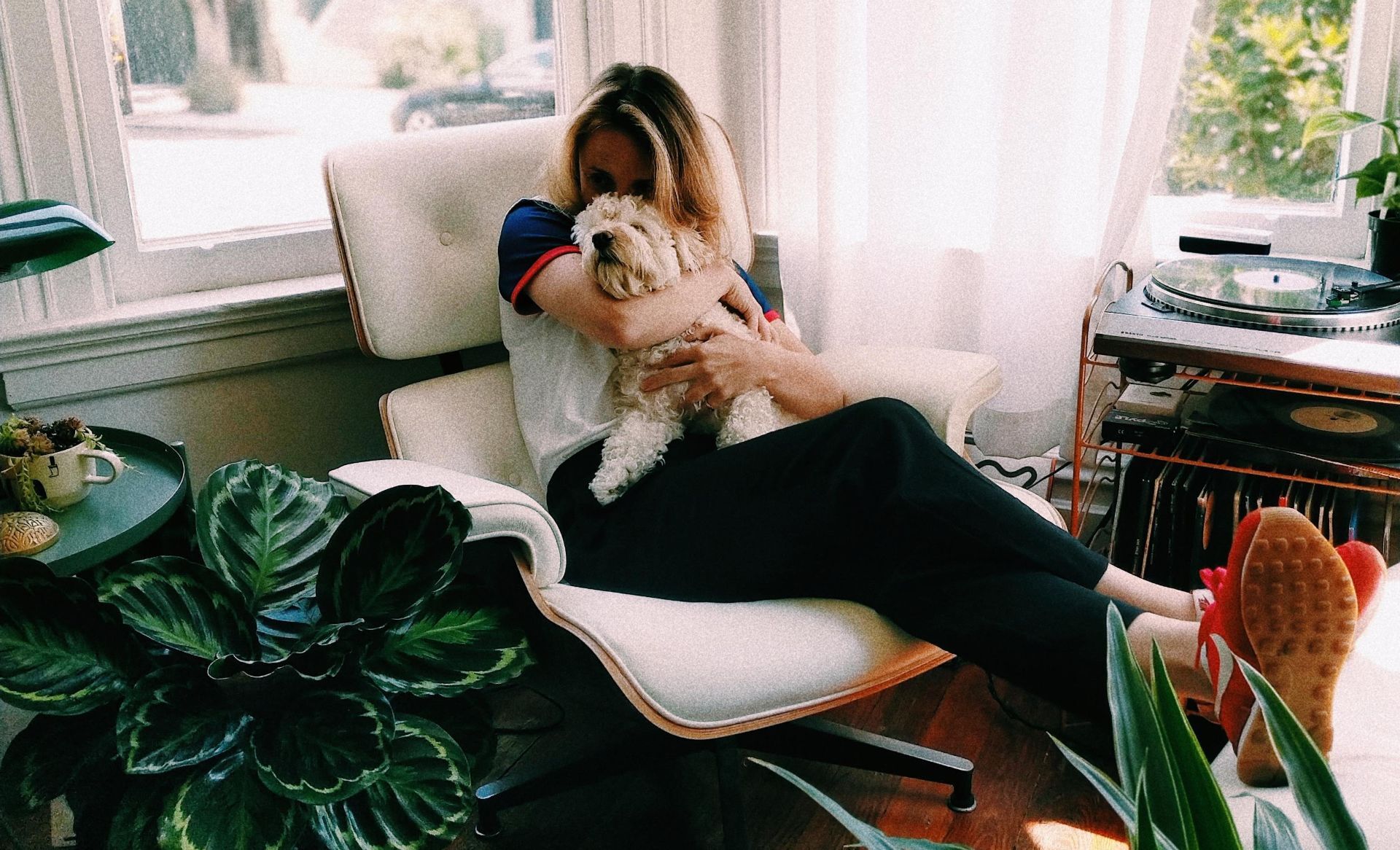 Kvinna som håller om en hund sittandes i en fåtölj