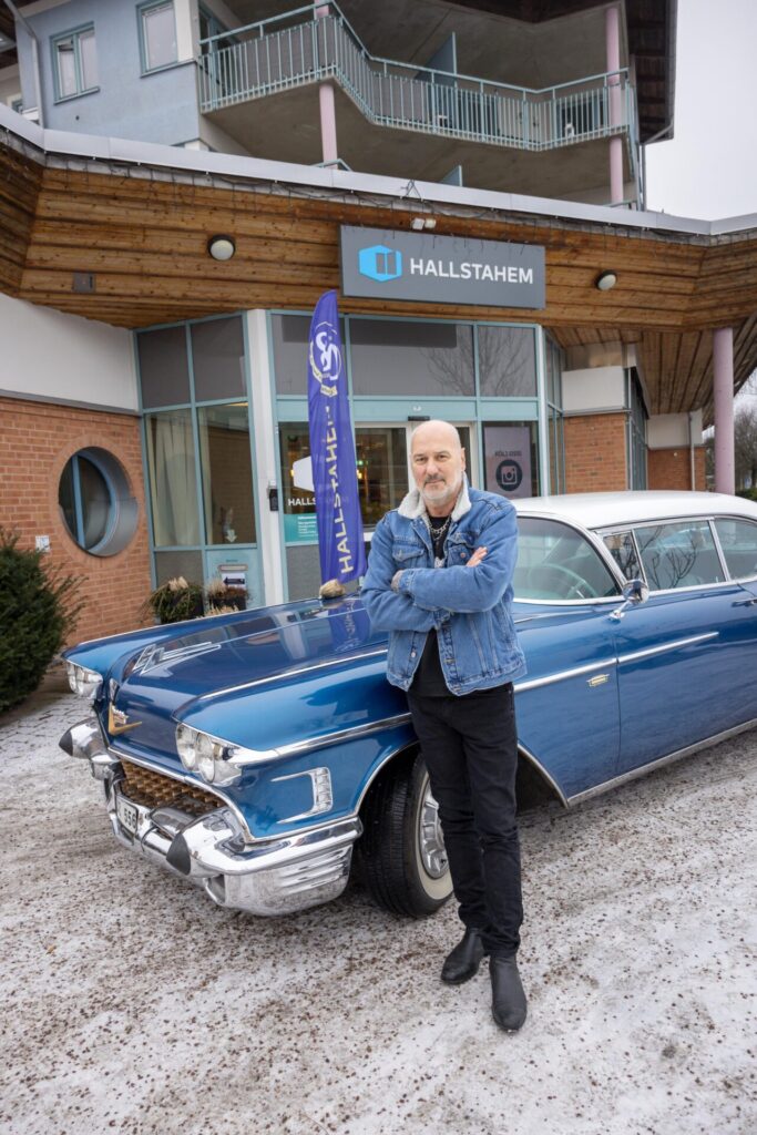 Man poserar framför bil